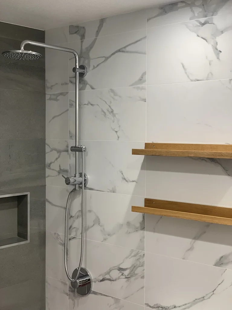 A bathroom shower with custom shelving